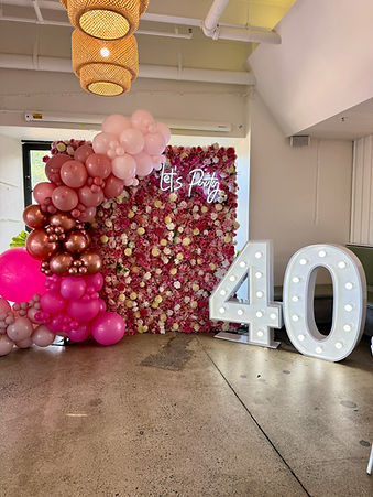 Giant 40 light up numbers with flower wall pink balloon garland and Lets Party neon sign a
