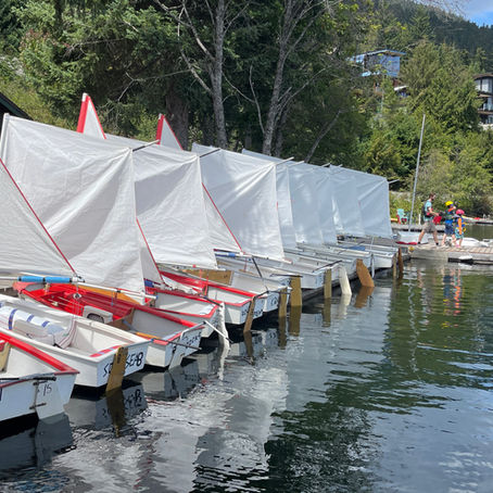 Optimist sailboats all rigged along the docks of whistler sailing. 