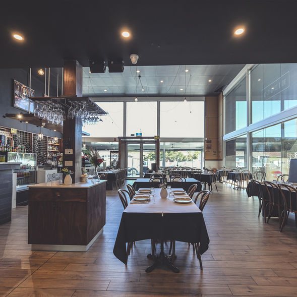 Spacious and elegant dining area with modern décor, wooden interiors and neatly set tables at Poetry – The Beauty of Indian Flavours restaurant