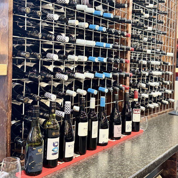 Curated wine collection displayed in an elegant rack, offering premium reds and whites that perfectly complement the poetry and beauty of Indian flavours