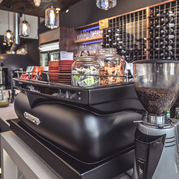 Modern café counter with premium coffee machine, fresh beans and service essentials at Poetry – The Beauty of Indian Flavours restaurant