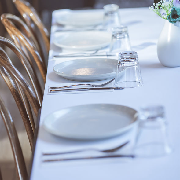 Elegant table setting at Poetry – The Beauty of Indian Flavours featuring neatly arranged plates, cutlery, and glassware in a refined dining space