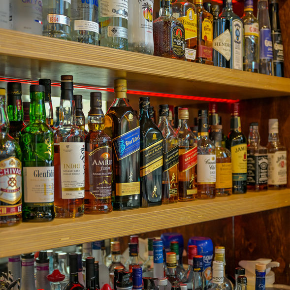 A well-stocked bar display featuring premium whisky, rum, vodka and spirits at Poetry – The Beauty of Indian Flavours restaurant