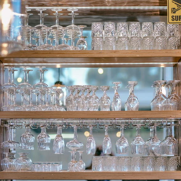 Neatly arranged crystal glasses on wooden shelves inside Poetry – The Beauty of Indian Flavours restaurant
