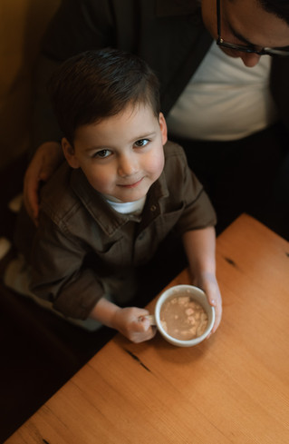 young boy sips on hot chocolate