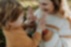 mom plays clapping game with toddler during a family photographer session in portland