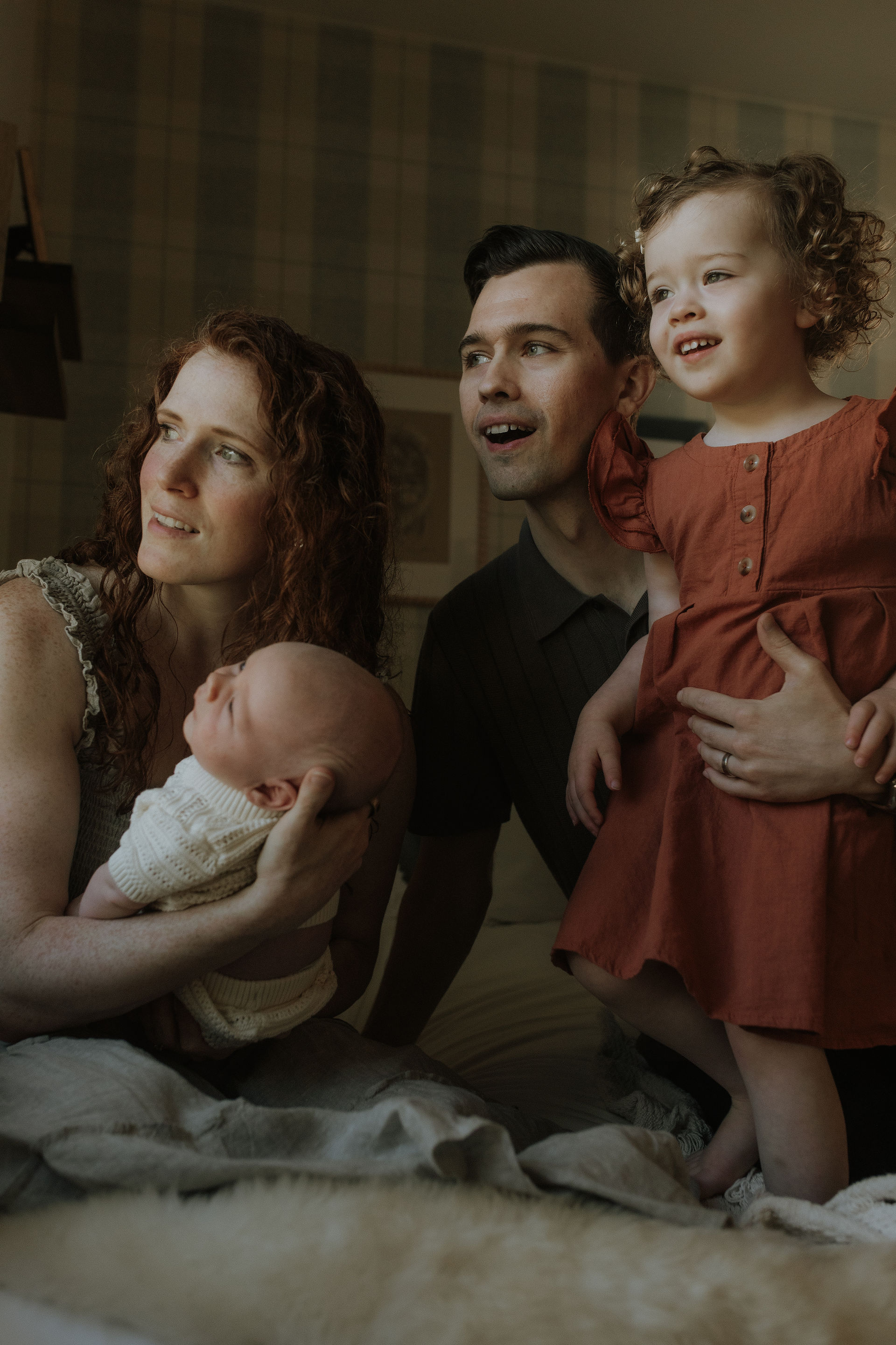 family looks out window during their in-home photography session