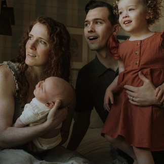 family looks out window during their in-home photography session