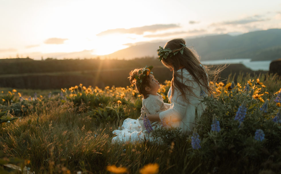 mom and baby snuggle during a wildflower photography session in the Columbia river gorge near Portland