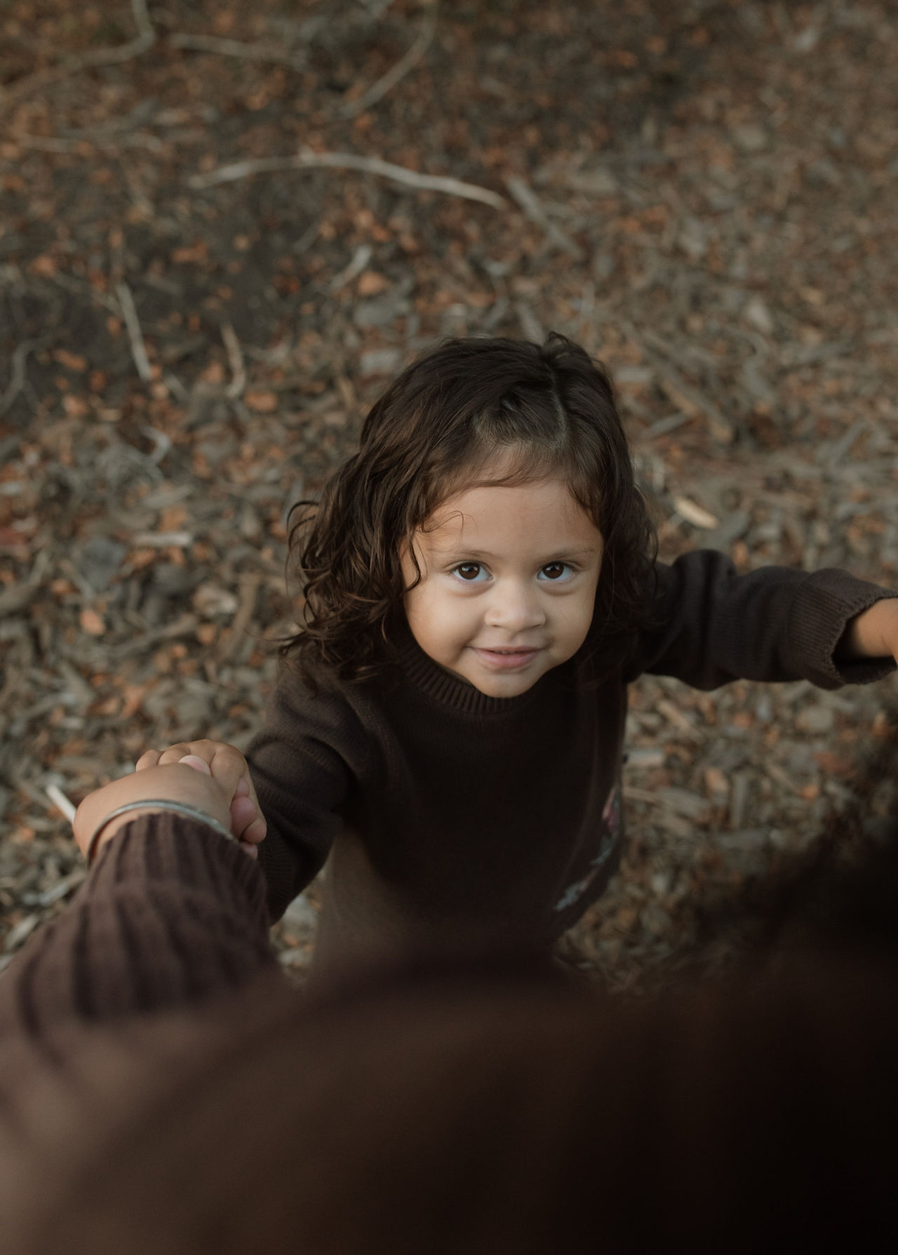 a daughter looks up at the camera while dancing with her mom