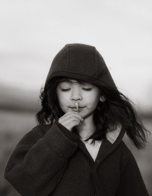 a daughter sniffs a wildflower in the Columbia river gorge