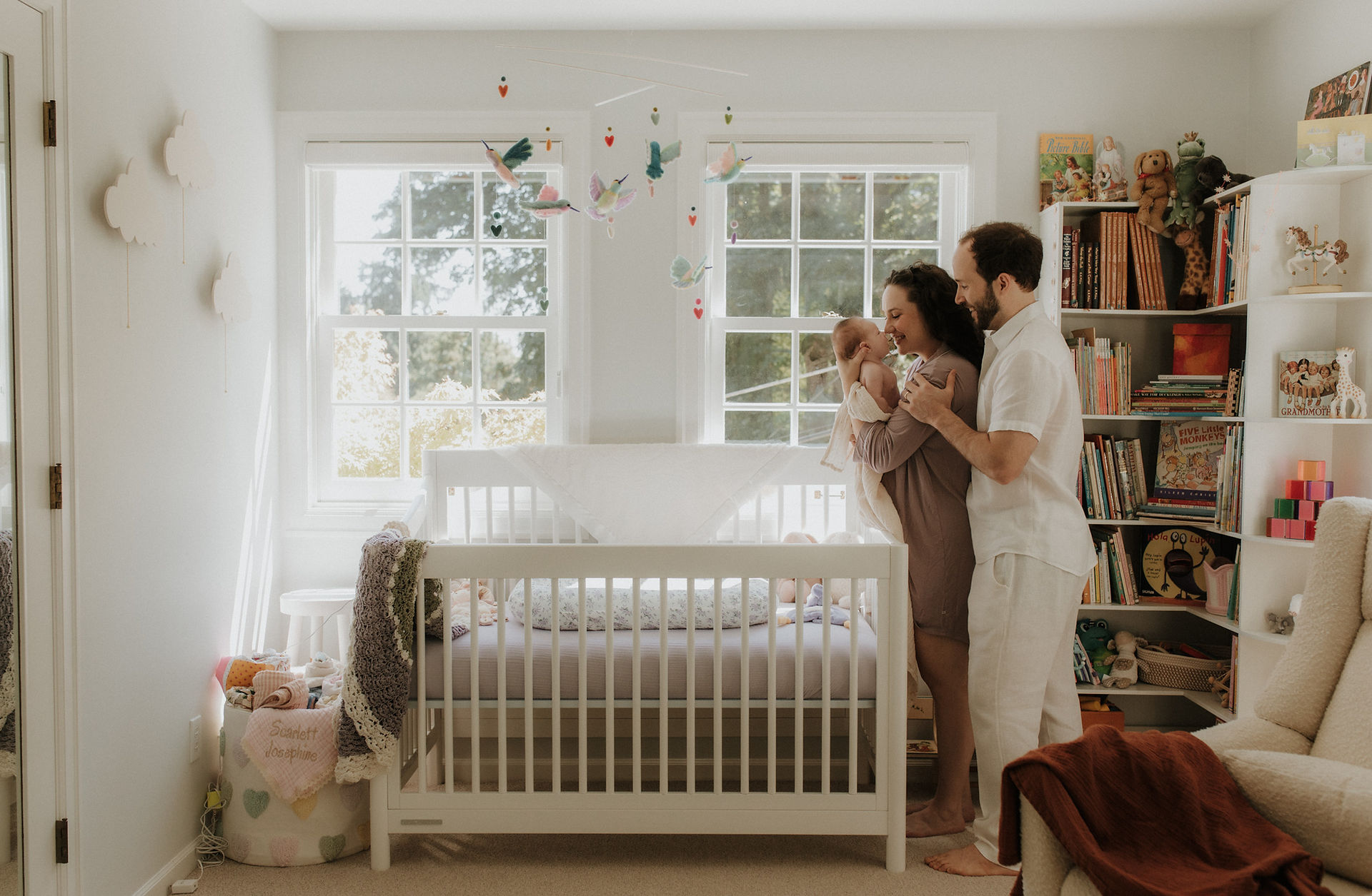 a mother and father greet their newborn in the nursery of their portland home
