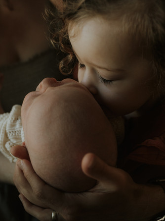 older daughter kisses baby brother