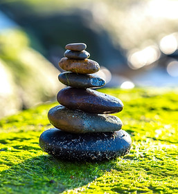Peaceful nature scene featuring a carefully balanced stack of smooth stones placed on a mo