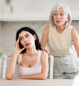 Elderly woman during family quarrel with young woman in kitchen at home.jpg
