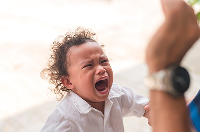 An upset young boy with curly hair having a tantrum after not getting his toy back Emotion