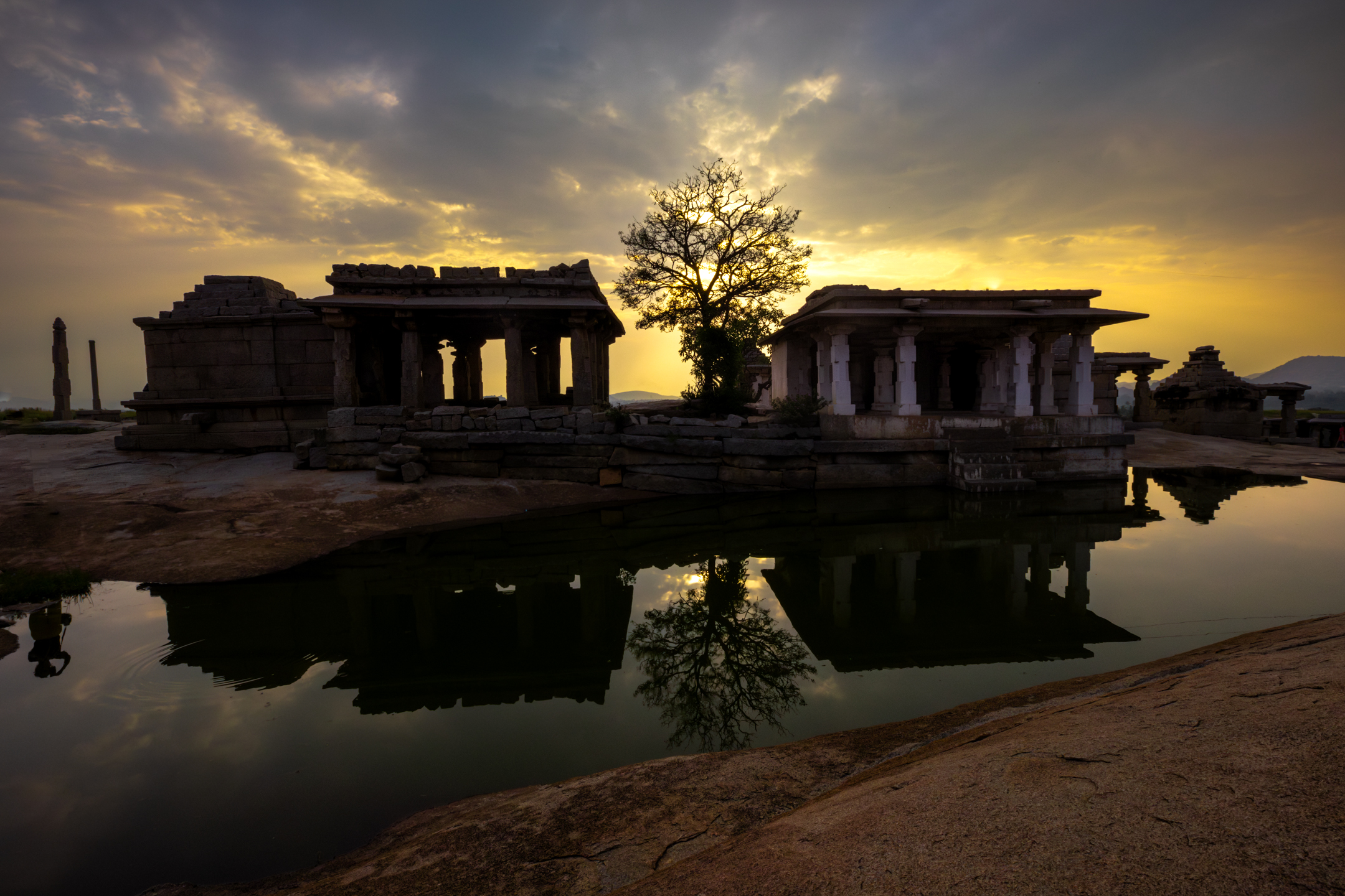 Ancient ruins reflected in water at sunset