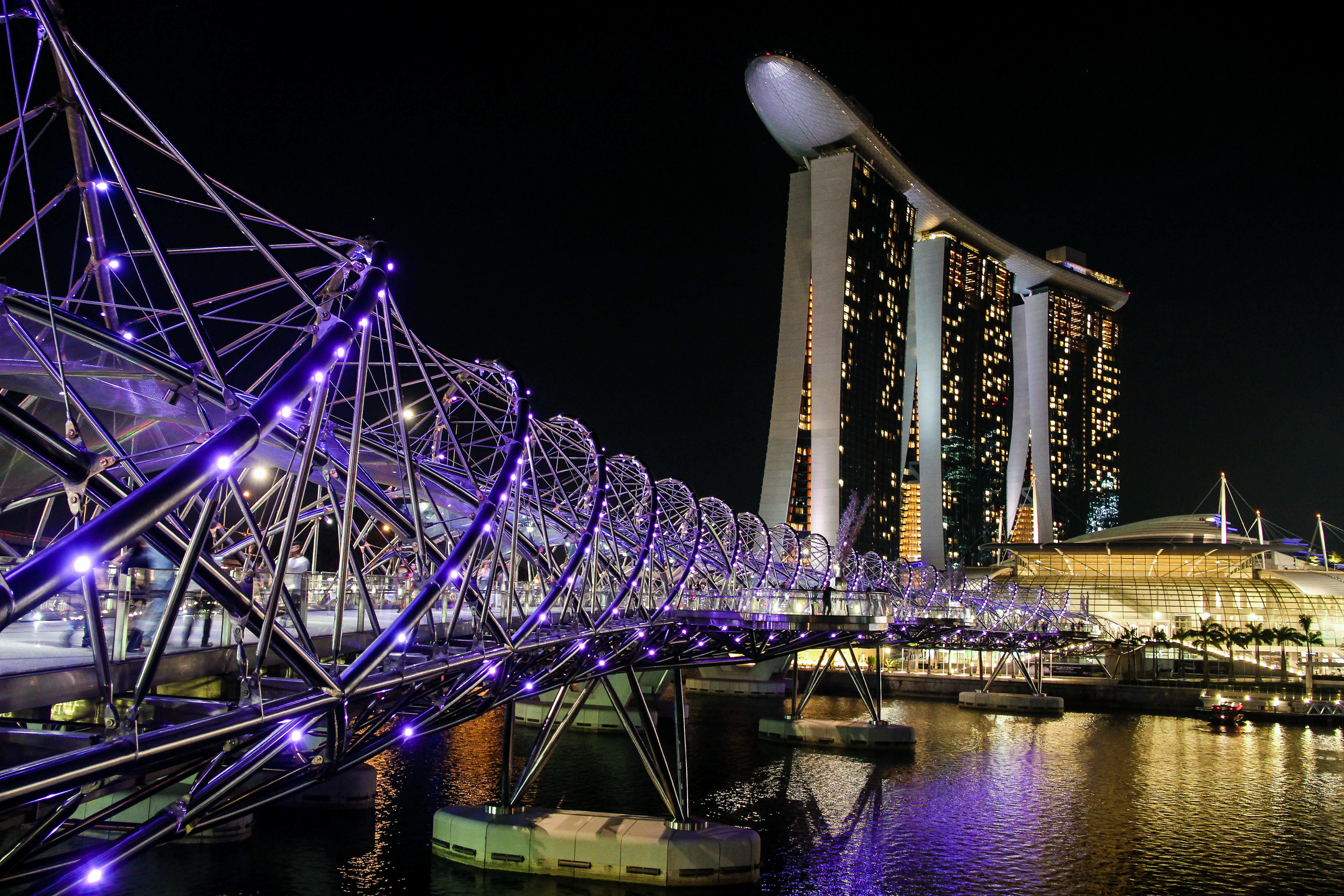Helix Bridge and Marina Bay Sands illuminated at night in Singapore