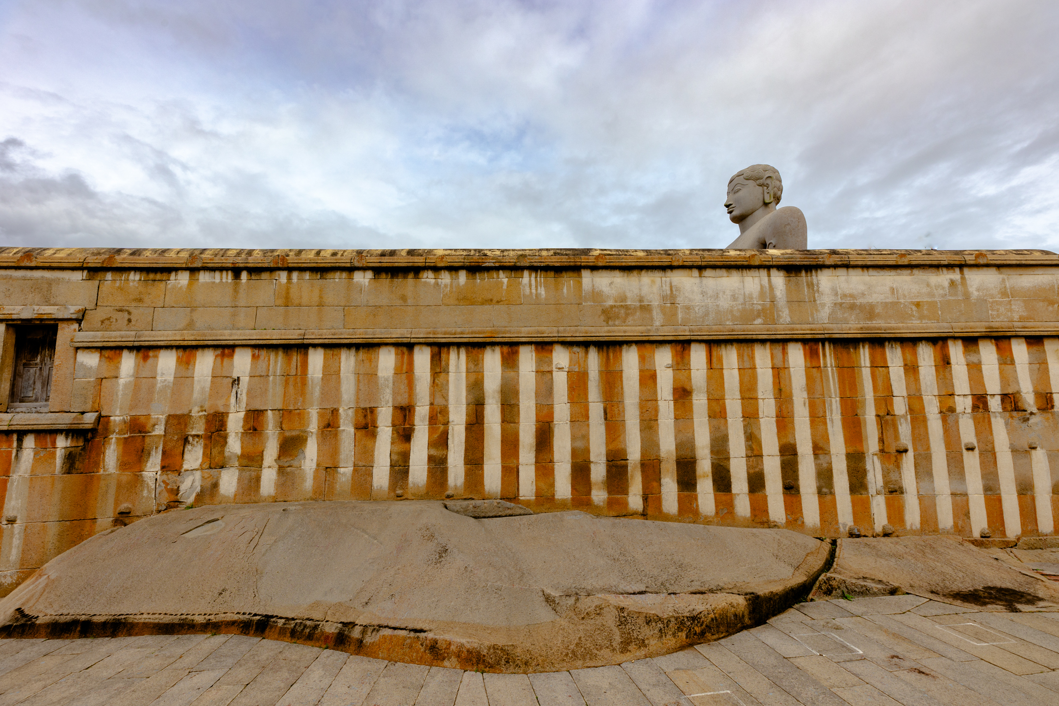 Weathered stone and a striped wall in an urban setting