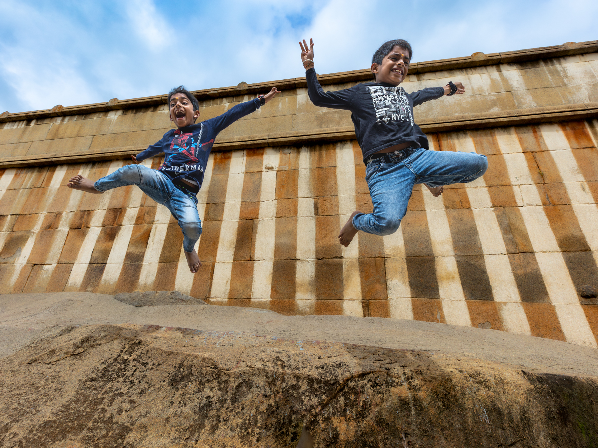 Two boys jumping outdoors in a fleeting moment of movement