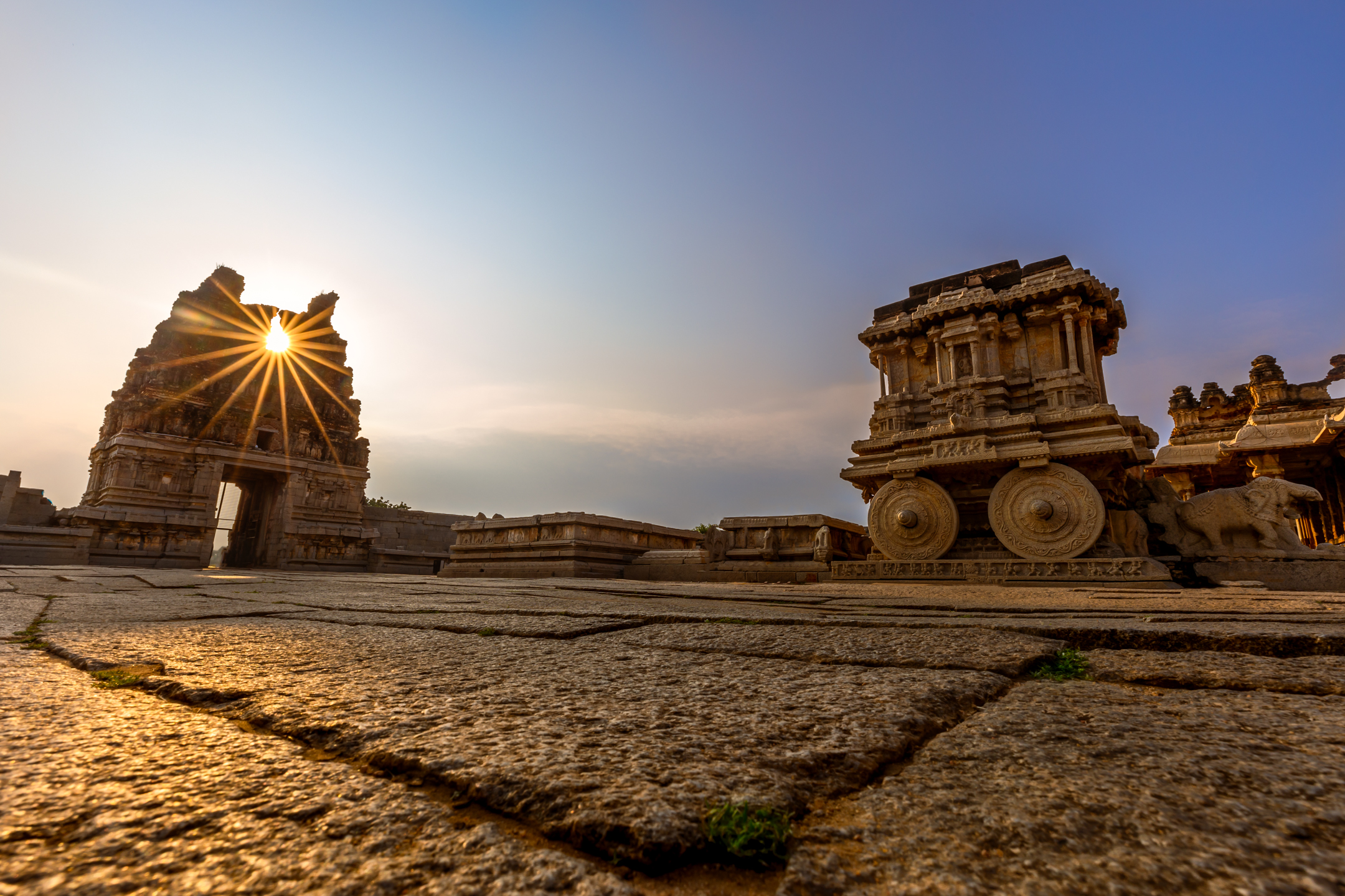 Ancient stone chariot and temple ruins at Hampi in warm evening light