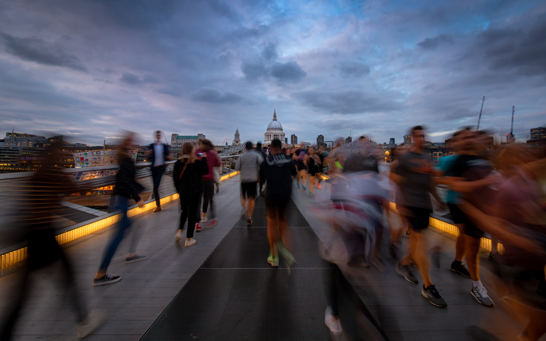 A person walking across a bridge in an urban setting