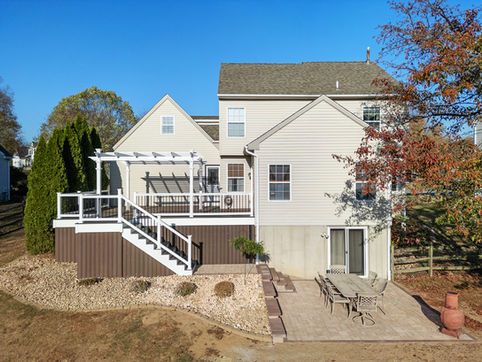 Overhead view of full composite deck with railing, pergola, stairs, and patio in Kennett Square