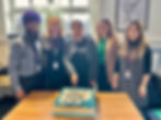The Walsall For All team at the celebration, Chair A'isha Khan cuts a cake