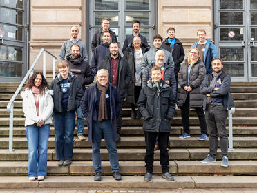 COIN project team pose for a photo on steps outside
