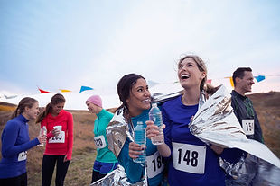 Marathon runners smiling at the finish after following a personalised sports nutrition plan