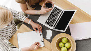Two women working on a laptop and notepad