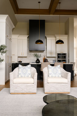 Minimalist living room with neutral tones, soft textures, and a mix of matte black and brass accents.