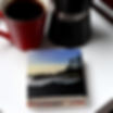 Tofino Beach image printed on stone coasters on a tray with a mug filled with coffee and a craft. Niagara ON