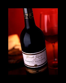 A bottle of red wine with a glass half full behind it. Scarfone Imaging, Commercial Photography in Niagara 
