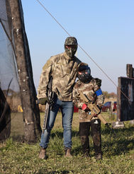 A man and his young son wearing camouflage and holding paintball guns at DMZ Canada, Niagara's best paintball and airsoft field, Thorold Ontario