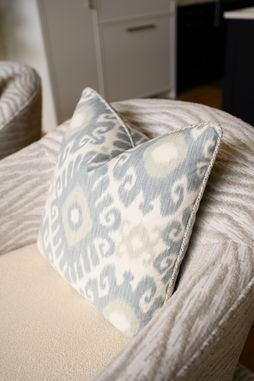 Minimalist living room with neutral tones, soft textures, and a mix of matte black and brass accents.