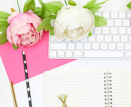 pink and white peonies on keyboard with blank notebook and pink envelope
