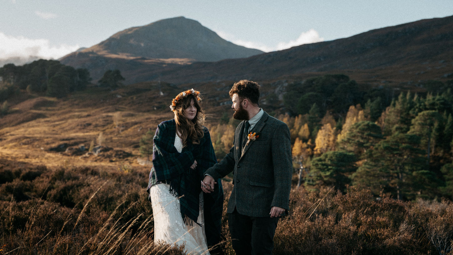 Bride and groom holding hands in the Glen Affric forest, Scottish Highlands