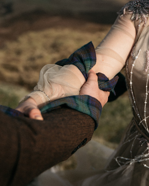 Close-up of bride and groom’s hands bound together in handfasting ritual at Quiraing ceremony, Isle of Skye