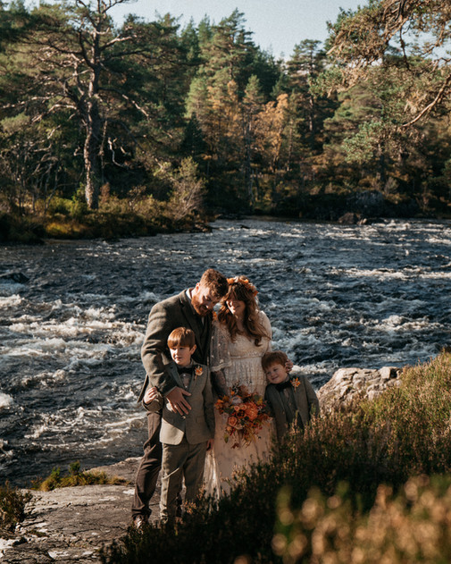 Family enjoying relaxed portraits by the river during Josh and Emily’s Glen Affric Vow Exchange in autumn.