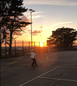 boy ride on surfskate with sunset