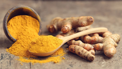 Turmeric powder and fresh turmeric on wooden background..jpg