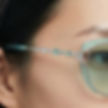 Close-up side view of green-tinted sunglasses worn by a model.
