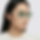 High quality visual of female model wearing green-tinted sunglasses in a clean fashion portrait.