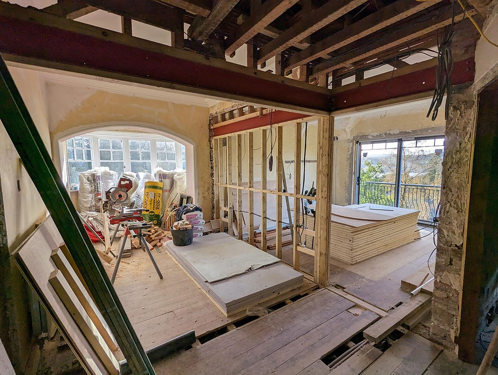 Renovation in progress with exposed joists, steel beams and timber partitions.