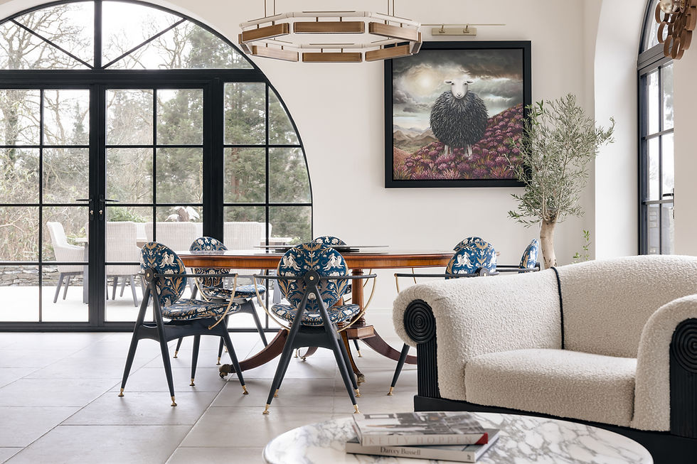 Blue and gold patterned dining chairs beside a large arched window.