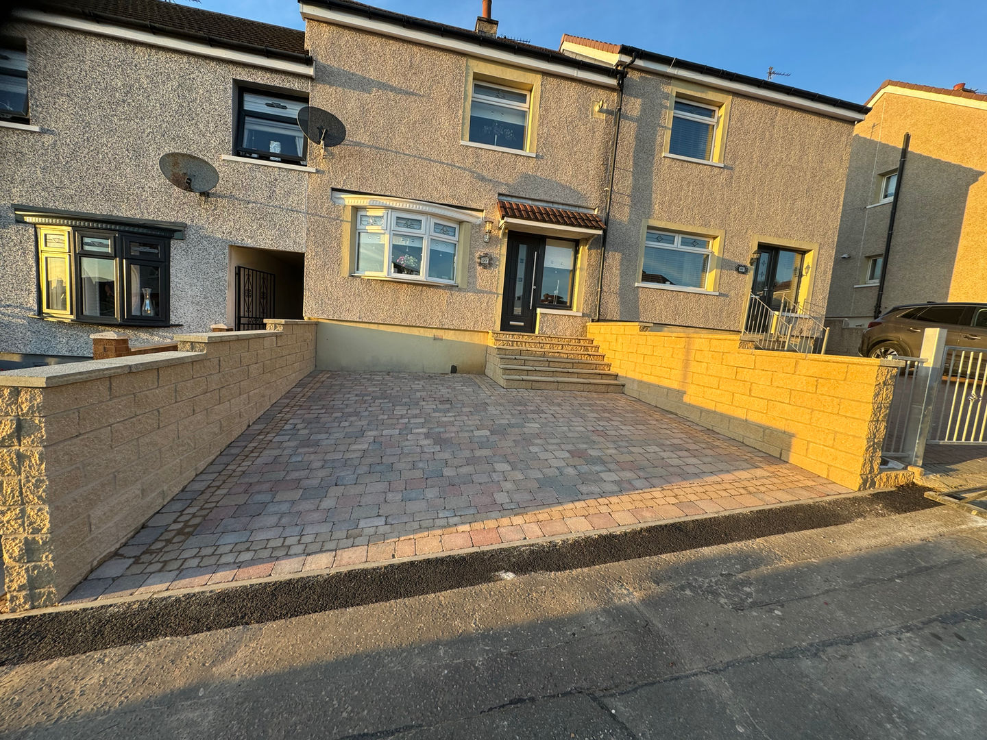 Brick driveway in front of two-story homes