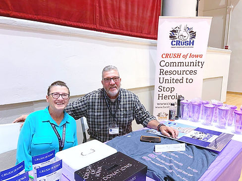 Debbie smiling in a blue shirt next to her husband Rod smiling in a plaid shirt at a CRUSH event.