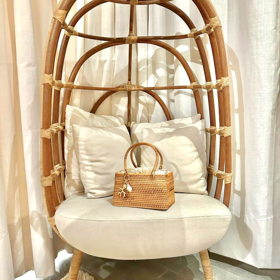 Pequena Bolsa Dani de vime sobre uma cadeira de rattan