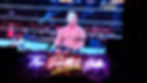 Wrestler in ring during event, crowd cheering. Neon "The Rabbit Hole" sign below. Energetic atmosphere with bold lighting and colors.